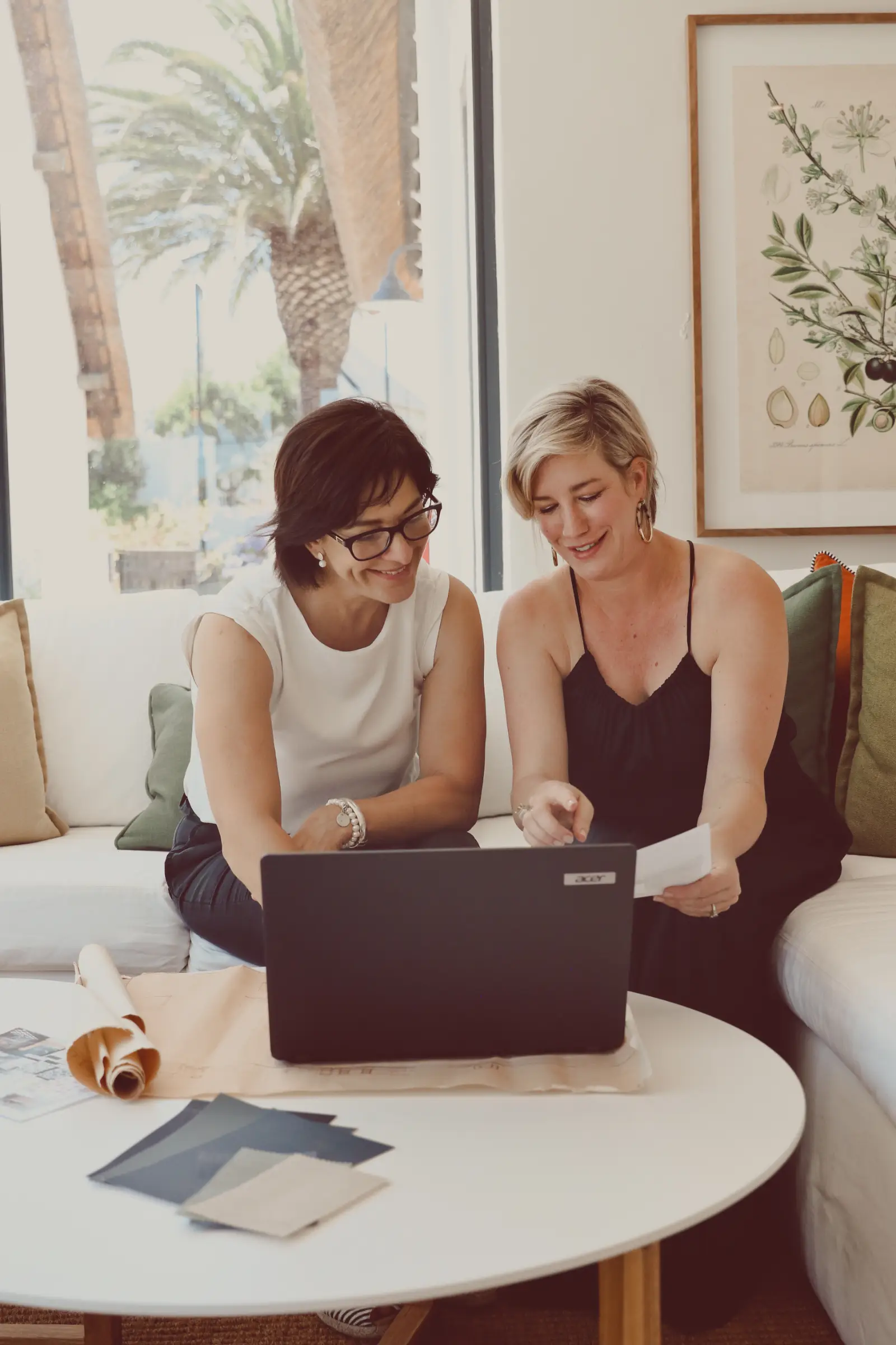 Carol and Liesl discussing a project in front of a laptop.