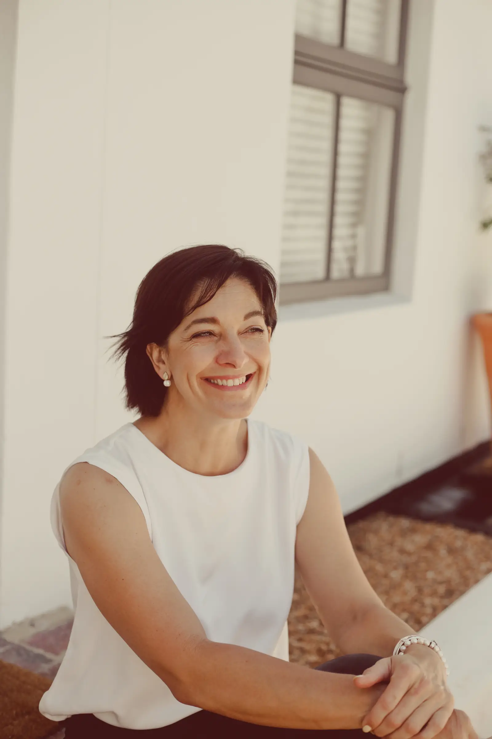 Carol wearing a white shirt smiling for a portrait.