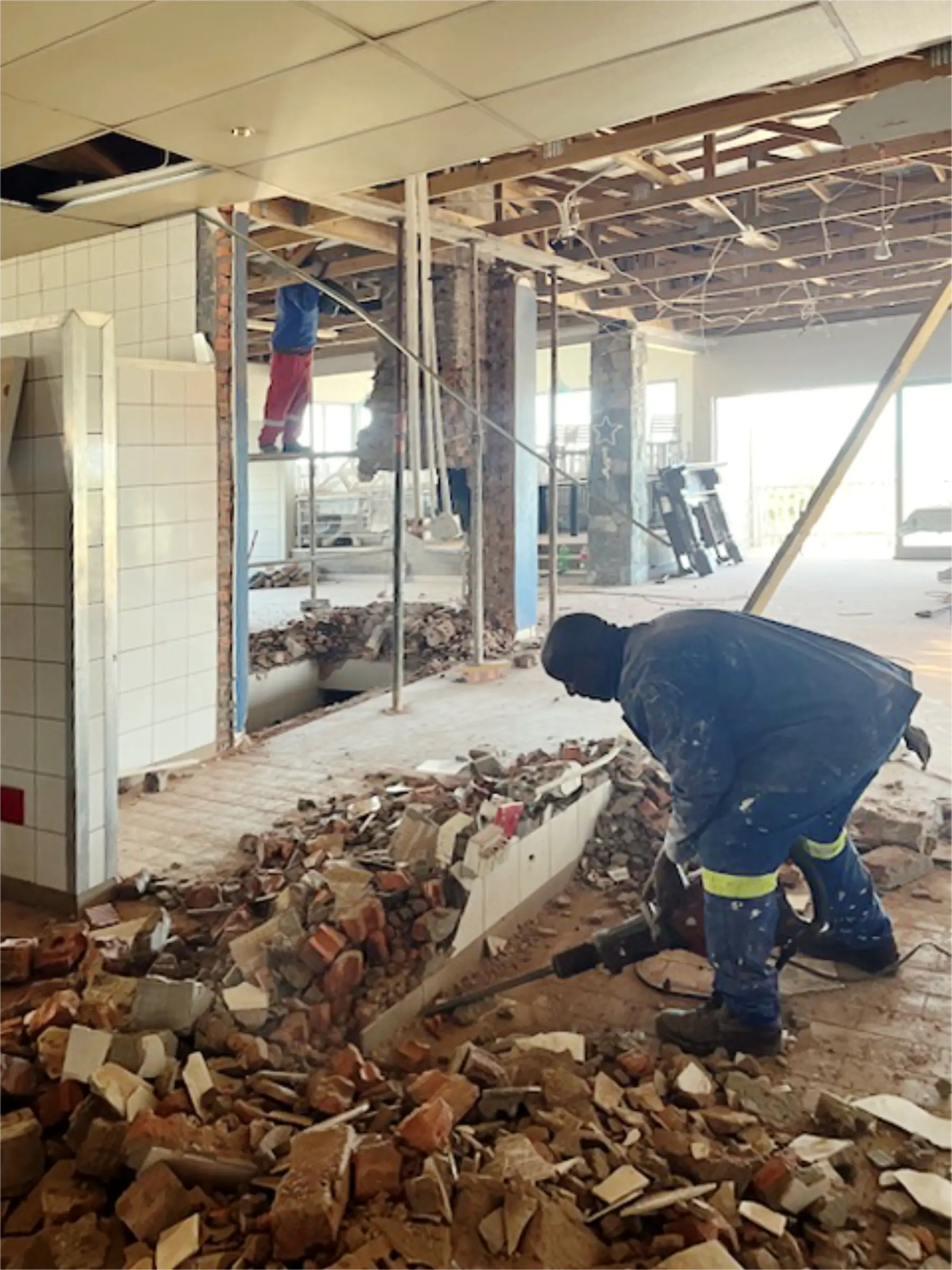 Workers busy working in rubble of old walls that were torn down.