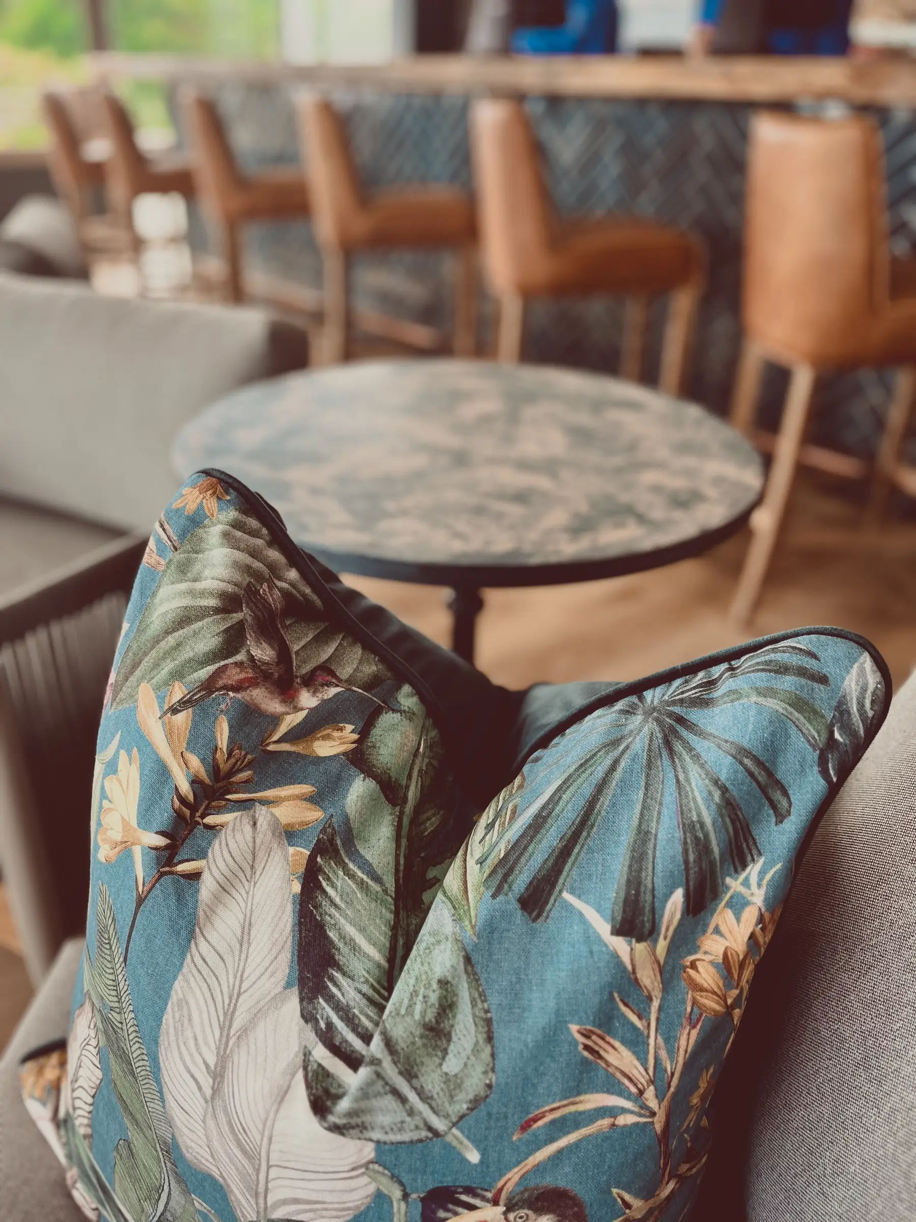 A stylish throw pillow inside the Glentana building with newly-renovated bar and tables in the background.